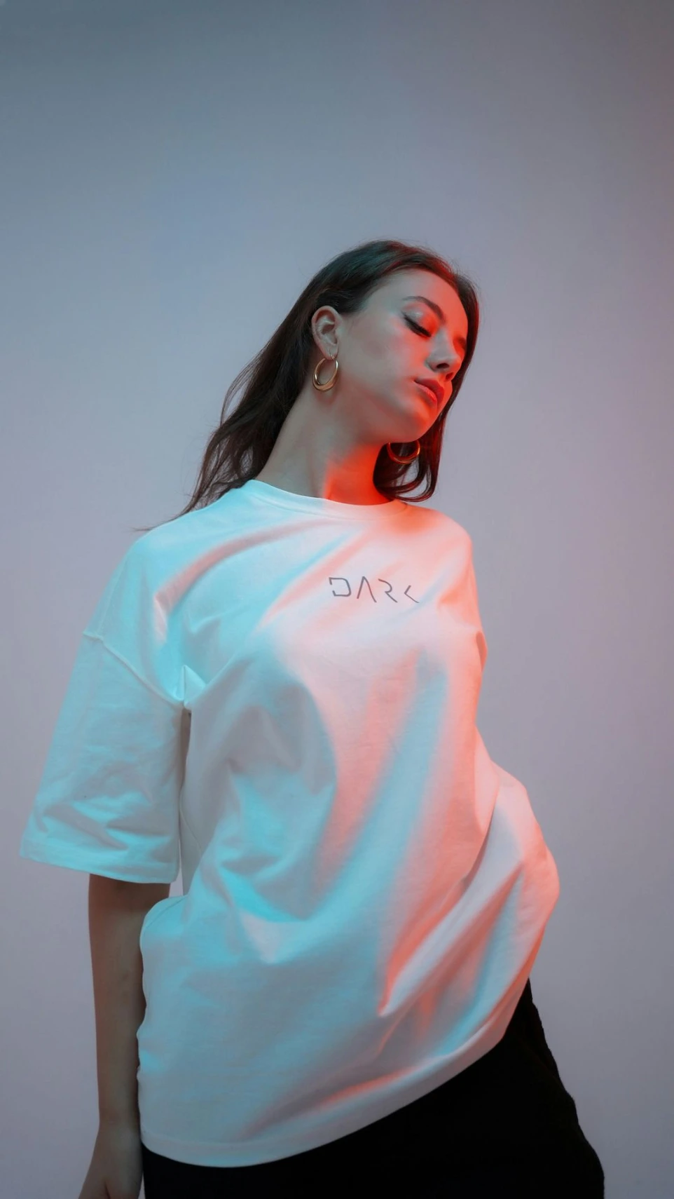 A woman in a white t-shirt with colored lighting.